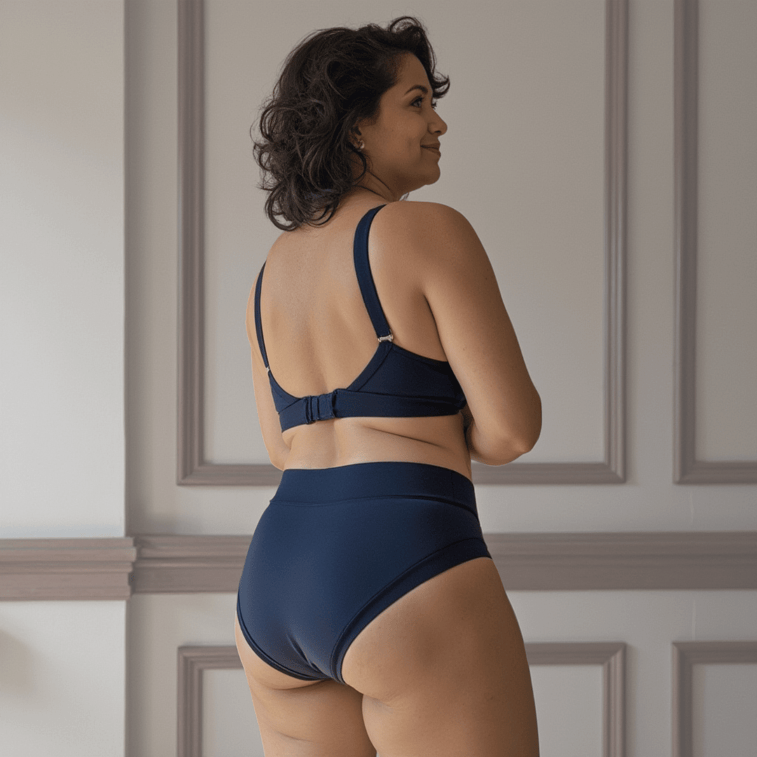Woman in her 40s turned away from the viewer wearing the high-waisted Emanate brief in Slate Navy 