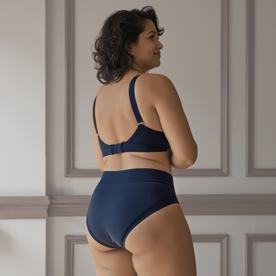 Woman in her 40s turned away from the viewer wearing the high-waisted Emanate brief in Slate Navy 