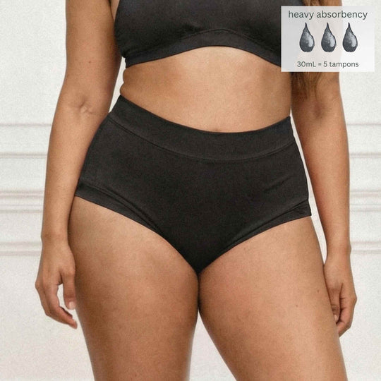 Front detail of Woman wearing the Wicks Intimates The Emily brief in black with absorbency badge.