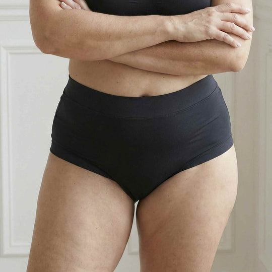 Woman with arms crossed wearing Wicks Intimates The Emily brief with extended gusset and high absorbency.