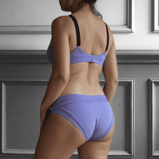 Woman in her 30s facing away from the viewer wearing the low-rise Engineered brief in periwinkle blue and made from GOTS certified organic cotton