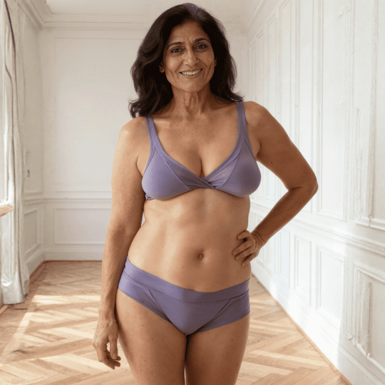 Woman in her 60s facing the viewer wearing the low-rise Engineered brief in Periwinkle blue made from GOTS certified organic cotton