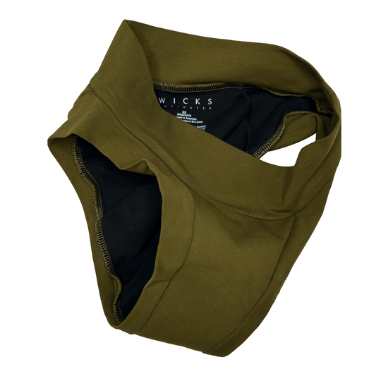 Artfully strewn flat lay image of Engineered Brief in Moss green made from GOTS certified organic cotton