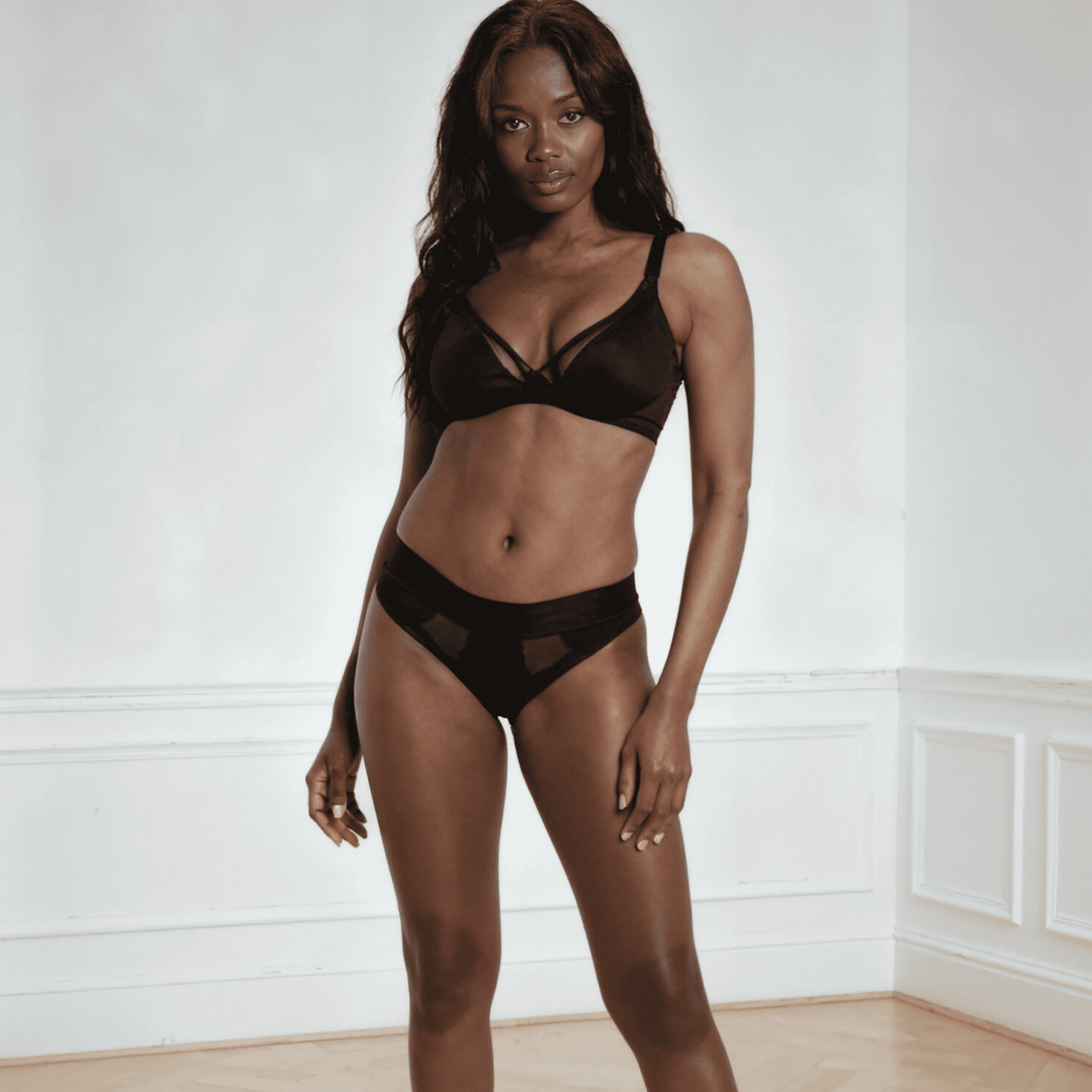 Woman in her 30s is facing towards the viewer wearing the size Small Striation Thong in Obsidian Black made from OEKO TEX certified fabric