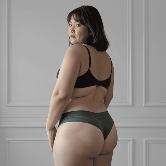 Woman in her 40s standing at an angle away from the viewer wearing the size XL Striation Thong made from OEKO TEX certified fabric