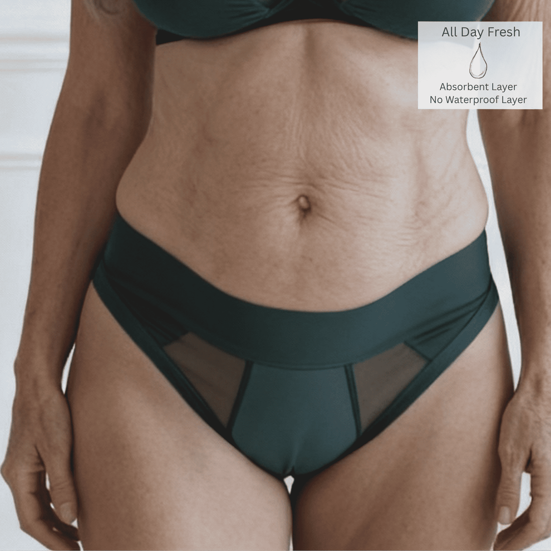 Detail of a woman in her 60s wearing the size Small Striation Thong in Forest green and made from OEKO TEX certified fabric. The All Day Fresh icon is in the top right of the image indicating that the garment has one absorbent layer but not waterproof layer