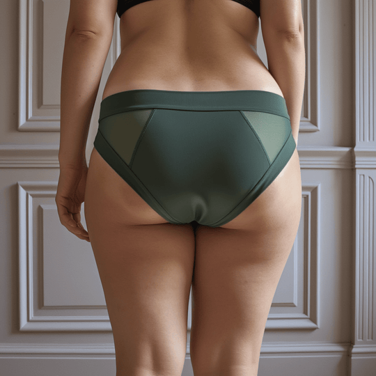Detail of woman in her 30s with her back to the viewer wearing the low-rise Swept Away brief in Forest green made from OEKO TEX certified fabric