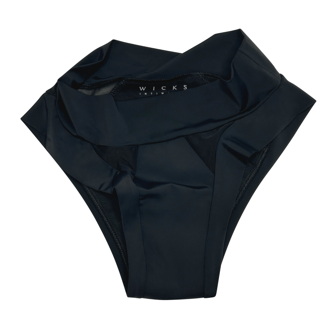 Artfully strewn flat lay image of low-rise Swept Away brief in obsidian black made from OEKO TEX certified fabric