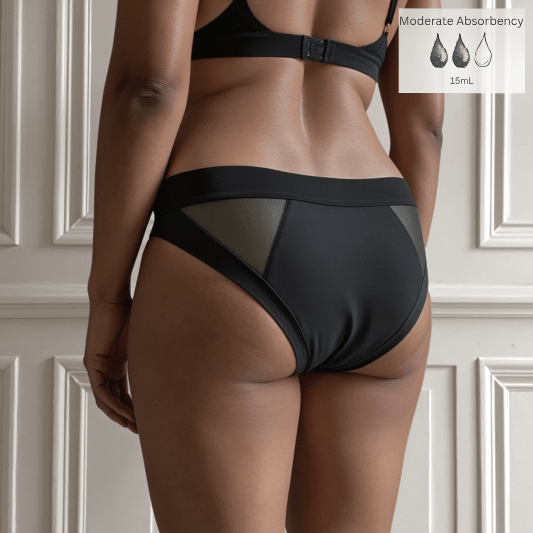 Detail of woman in her 30s with her back to the viewer wearing the low-rise Swept Away brief in Obsidian Black. A Moderate Absorbency icon is in the top right of the image