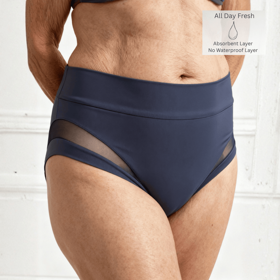 Detail of a woman in her 60s wearing the size M high-waisted Valley Brief in Slate Navy. All Day Fresh icon is in the top right of the image indicating there is one absorbent layer but no waterproof layer