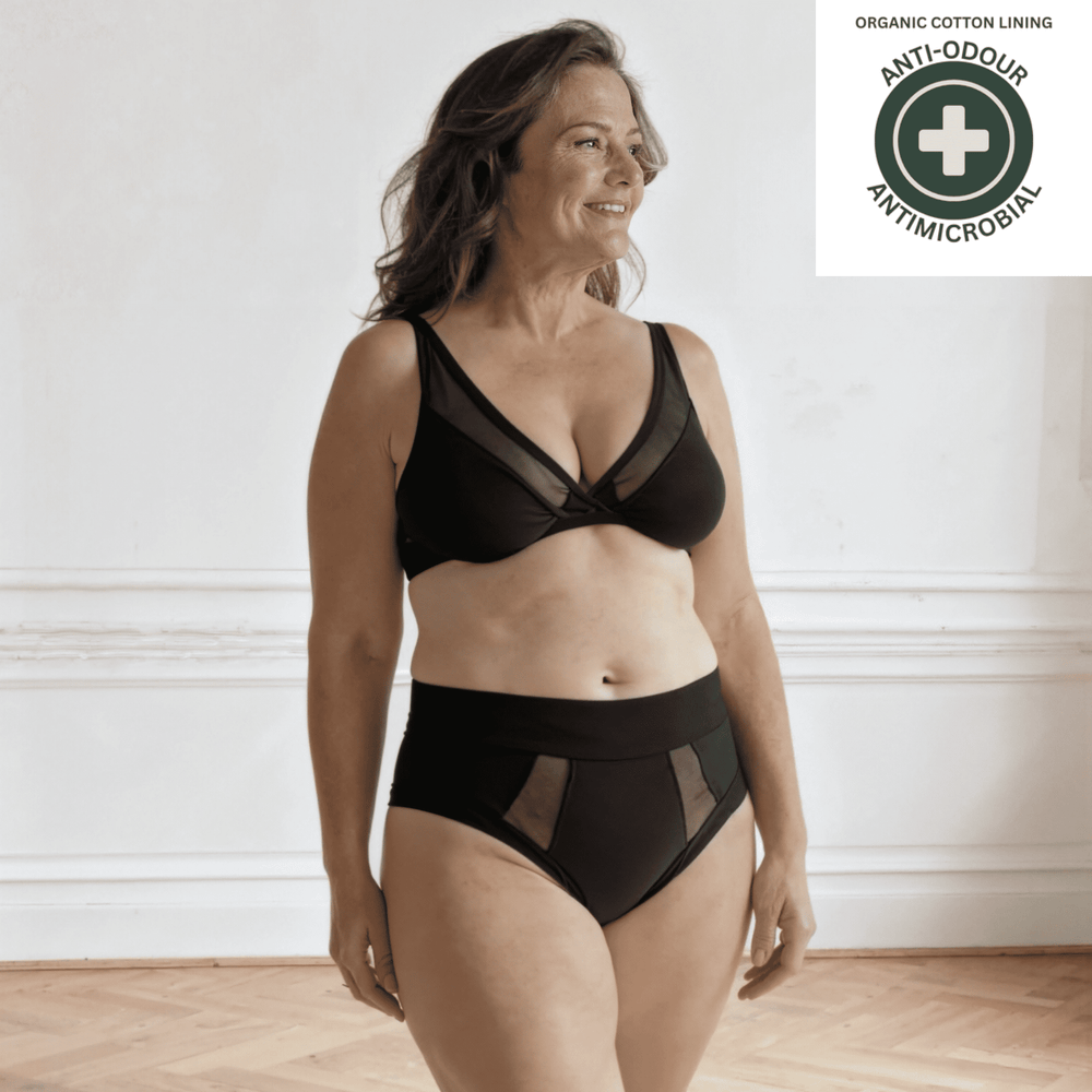 Woman wearing the Emanate brief in black with antimicrobial and anti-odour badge top right.