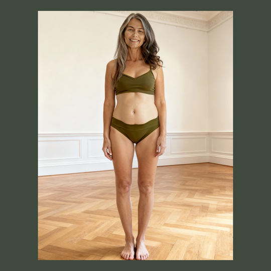 Woman wears low rise organic cotton absorbent briefs in moss green