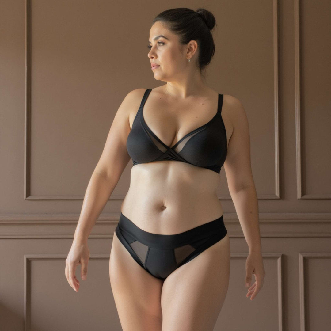 Woman wearing the low-rise Striation thong in obsidian black. For very light bladder leaks or spotting protection. OEKO-TEX certified butter-soft blend fabric.