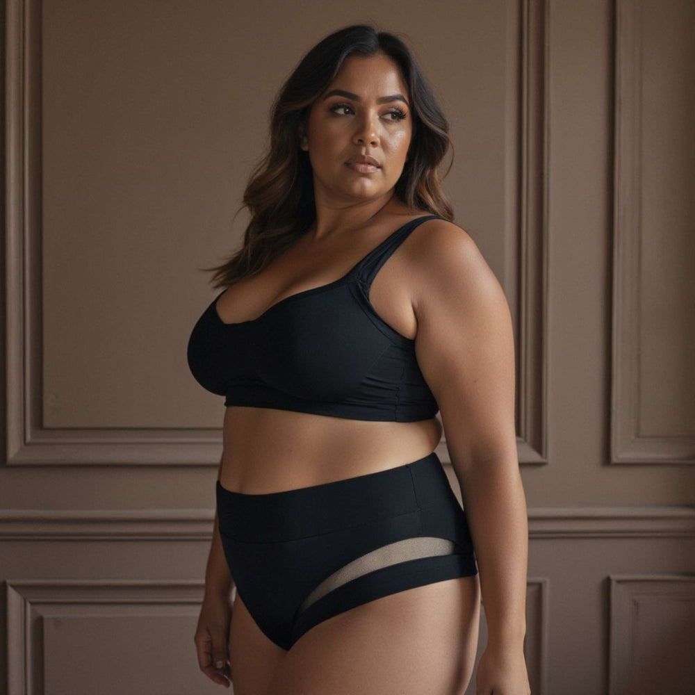 Woman wearing Valley brief in obsidian black. High-waisted with mesh panel detailing around the hips. Made from OEKO-TEX butter-soft blend fabric.
